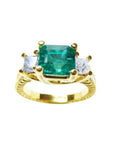 This emerald and princess cut side diamond three stone ring for women is made of 18k yellow gold.