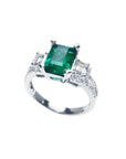 1.88 carat emerald ring with side emerald-cut and round diamonds in 18k white gold.