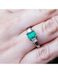 1.38 ct. Colombian emerald ring with two princess cut side diamonds in 18k white gold.