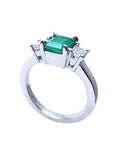 Side profile of a white gold three stone emerald ring.