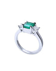 18k white gold three-stone ring with a rectangular emerald and two princess-cut side diamonds.