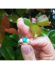1.88 carat emerald ring with side emerald-cut diamonds and round accents in 18k white gold.
