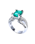 Emerald-cut Colombian emerald ring in 18K white gold with diamond accents.