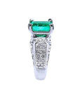 Emerald-cut Colombian emerald ring with diamond-encrusted 18K white gold band.