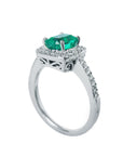 A 14k white gold cushion emerald ring on a half side profile view.