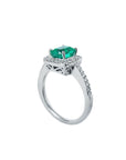 A 14k white gold cushion emerald ring on a half side profile view.