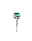 Cushion cut emerald ring with diamond halo and pavé band in 14K white gold.