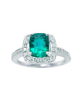 This cushion cut emerald ring for women is adorned with natural diamonds encircling the emerald in white gold