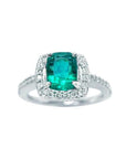 This cushion cut emerald ring for women is adorned with natural diamonds encircling the emerald in white gold