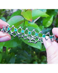 14K white gold bracelet with round Colombian emeralds bezel-set in diamond-shaped links.