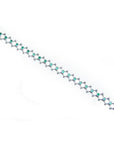 14K white gold bracelet with round Colombian emeralds bezel-set in diamond-shaped links.