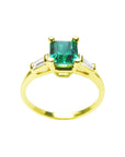 A natural emerald with side baguettes diamond ring yellow gold, topside and lateral profile view.