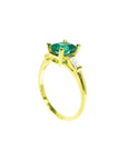 Side view of a yellow gold emerald and side baguette diamond ring