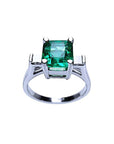 An emerald-cut real Colombian emerald ring in white gold top and partial gallery view.