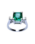 A GIA certified 1.56 ct emerald ring with princess-cut side diamonds in 14K white gold.