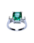A GIA certified 1.56 ct emerald ring with princess-cut side diamonds in 14K white gold.