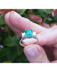 1.62 carat emerald engagement ring with side princess cut diamonds in 14k white gold.