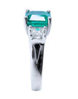 Side profile of this emerald ring accent princess cut diamonds white gold.
