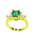 18k gold ring with a 1.51 ct. emerald and two trillion-cut side diamonds.