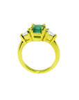 18k gold ring with a 1.51 ct. emerald and two trillion-cut side diamonds.
