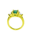 18k gold ring with a 1.51 ct. emerald and two trillion-cut side diamonds.