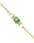The topside view of a square emerald solitaire bracelet prong set in 14k yellow gold.