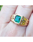 Men's 14K yellow gold solitaire ring with a bezel-set, deep green Colombian emerald.