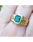 Men's 14K yellow gold solitaire ring with a bezel-set, deep green Colombian emerald.