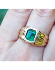 Men's 14K yellow gold solitaire ring with a bezel-set, deep green emerald.