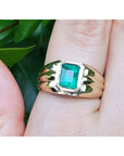 14k gold solitaire ring for men with a natural colombian emerald bezel set worn on a hand.