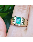 14k gold solitaire ring for men with a natural colombian emerald bezel set worn on a hand.