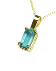 A yellow gold emerald solitaire pendant showing the topside and gallery profile.