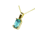 A yellow gold emerald solitaire pendant showing the topside and gallery profile.