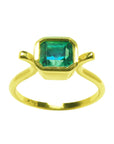 The topside perspective of a solitaire emerald ring bezel set in yellow gold
