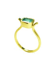 0.81 ct. emerald solitaire ring, bezel set in 14K yellow gold with a medium bluish-green stone.