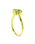 A side perspective of a solitaire emerald ring bezel set in yellow gold