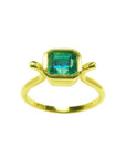A solitaire natural colombian emerald ring bezel set in 14k yellow gold.