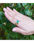 Men's 14K gold solitaire ring with a bezel-set Colombian emerald and Greek Key design.