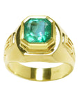 A natural men's colombian emerald ring displaying a topside position and sideways perspective.