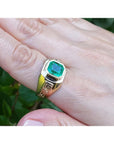 Men's 14K gold solitaire ring with a bezel-set octagonal Colombian emerald and Greek Key design.