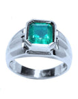 An 18k white gold men’s ring featuring a natural Colombian emerald in a bezel-set solitaire design.