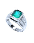 Men's white gold natural emerald ring on a white background.
