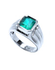 Men's 18K white gold ring with a bezel-set, rectangular Muzo emerald solitaire.