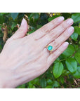 2.14 ct rectangular Colombian emerald solitaire ring, bezel set in 14K yellow gold on a hand.