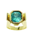 Colombian emerald solitaire ring for women bezel set in 14k yellow gold.