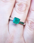 A Muzo mines genuine emerald solitaire silver ring on a finger