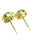 A pair of yellow gold emerald stud earrings underside post's view push backs.