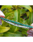14K gold tennis bracelet with round-cut natural Colombian emeralds, 7 inches long, held by manicured hands.