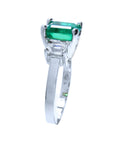 This three stone emerald and side diamonds engagement ring is displaying its top to downside profile.
