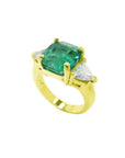 18k yellow gold ring with a large natural emerald and two trillion side diamonds.